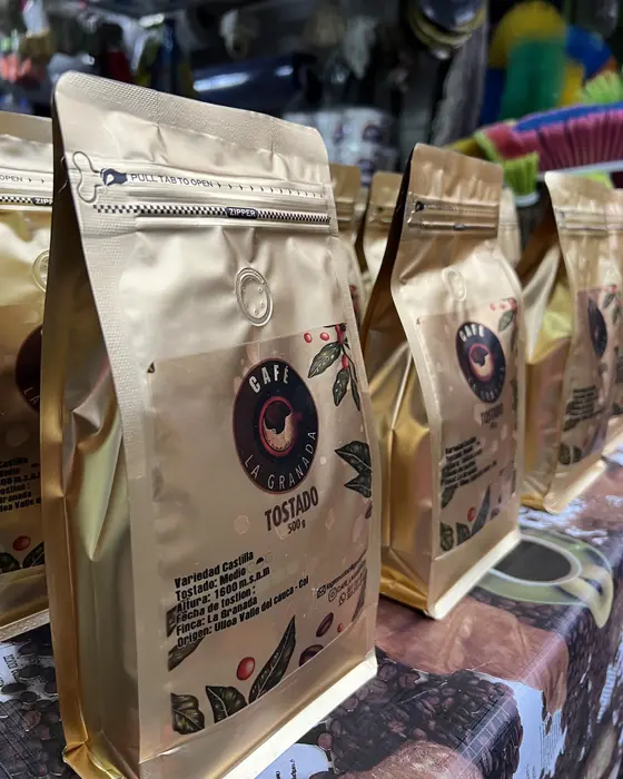 Bolsas doradas de Café La Granada exhibidas en un punto de venta