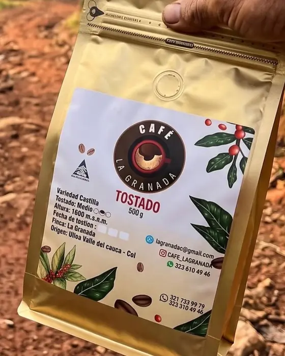 Bolsa de Café La Granada en la mano, en un camino de la finca en Ulloa
