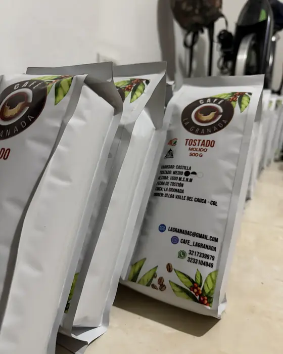 Fila de bolsas blancas de Café La Granada tostado y molido